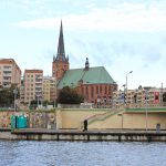 Stadtansicht von Stettin mit Backsteinkirche und Plattenbauten am Hafen